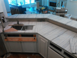 Installation of white marble kitchen countertops with a sink cutout in progress by Alfortish Marble & Granite, LLC in Baton Rouge, LA.