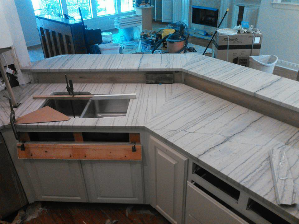 Installation of white marble kitchen countertops with a sink cutout in progress by Alfortish Marble & Granite, LLC in Baton Rouge, LA.
