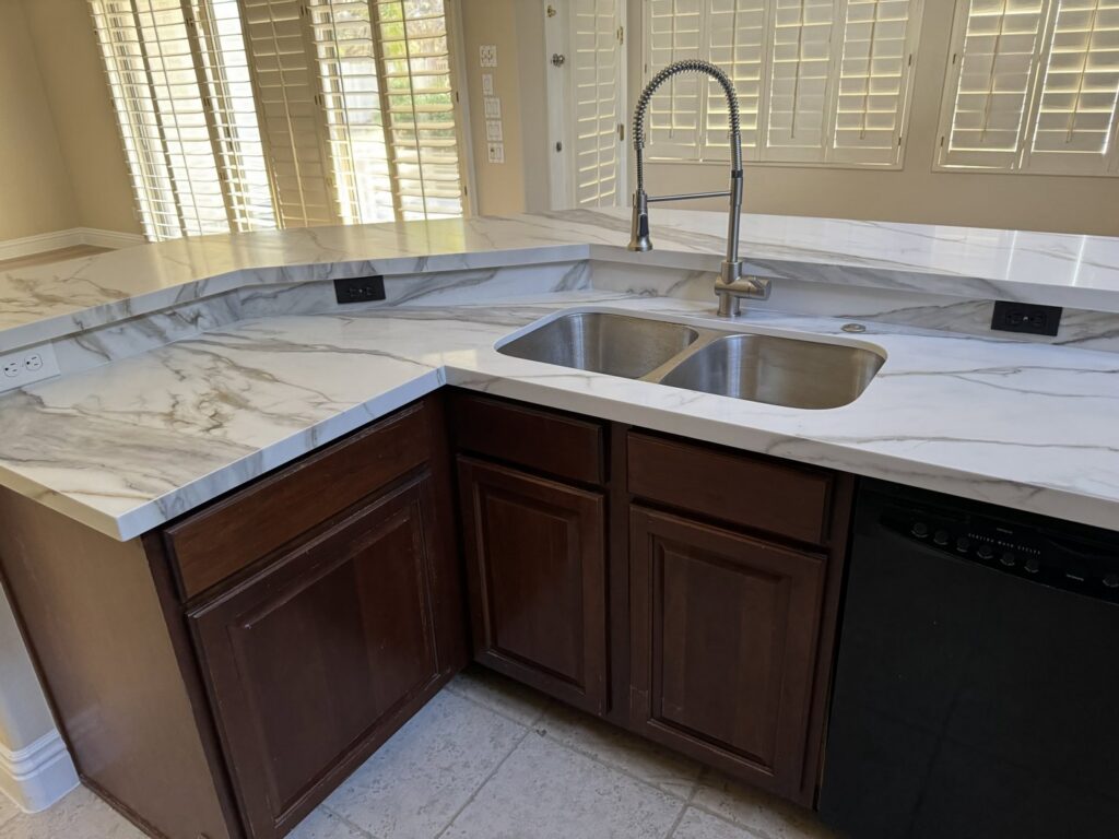 New white marble-look kitchen countertops and a double sink installed by Centennial Builders, LLC in Litchfield Park, AZ.