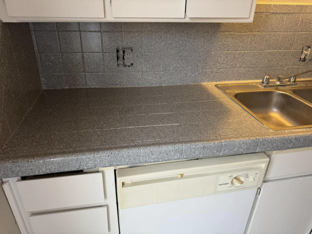 A newly resurfaced speckled grey kitchen countertop and backsplash by That Resurfacing Guy LLC in Oklahoma City, OK.