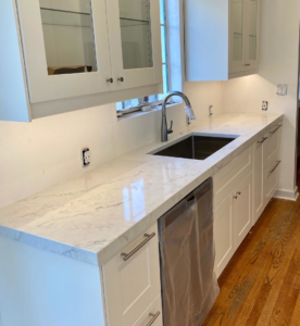 Newly installed white marble-look kitchen countertops and a stainless steel sink by Dorado Stone Inc. in Tucson, AZ.