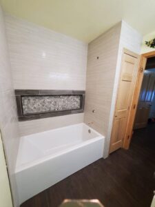 A renovated kitchen featuring new countertops and a light-colored backsplash by CSR Tile Construction LLC in Minneapolis, MN.