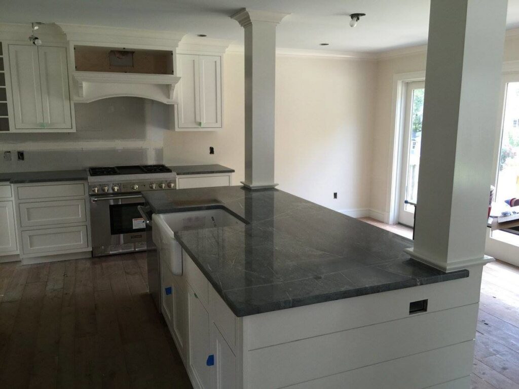 Kitchen with dark cabinets and granite countertop installation in progress by Art of Stone Shop in Bridgeport, CT.