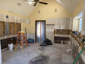 A kitchen renovation project in progress with demolition and construction tools visible, managed by AKN Design Group in Fort Worth, TX.