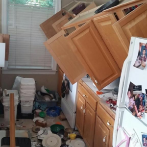 A messy kitchen with fallen cabinets and debris, showing a scene ready for junk removal by Roll With It in Appleton, WI.