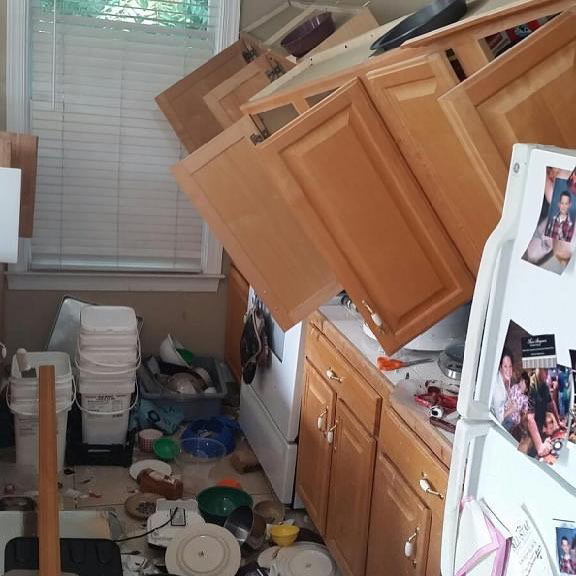 A messy kitchen with fallen cabinets and debris, showing a scene ready for junk removal by Roll With It in Appleton, WI.