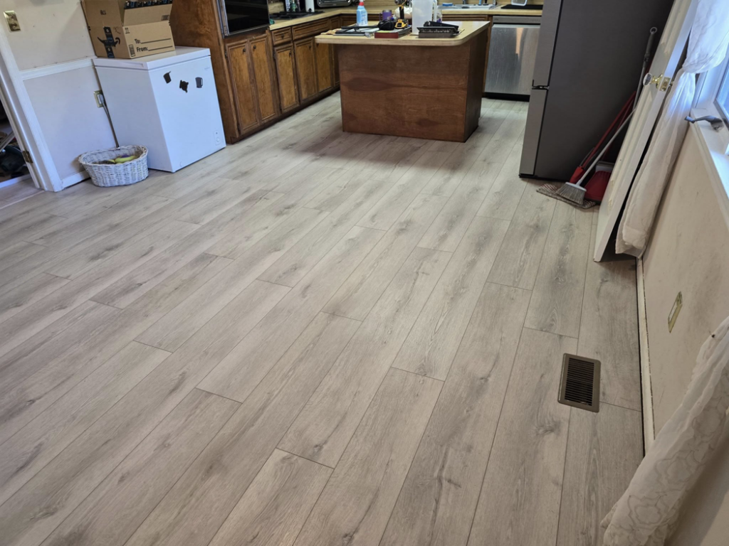 Spacious kitchen and dining area featuring new light hardwood flooring installed by Refined Hardwood Flooring LLC in Wilmington, NC