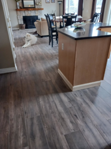 A kitchen island and dining area featuring new wood-look tile flooring by Home Improvement Design Center in Ann Arbor, MI.