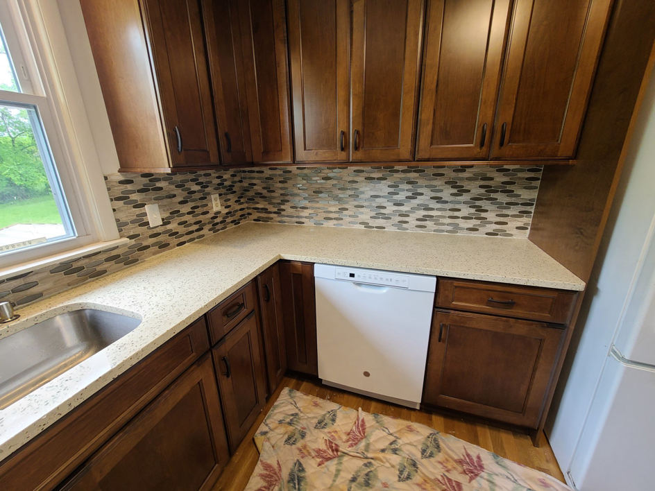 A kitchen renovation featuring a newly installed dishwasher, fresh countertops, and a modern backsplash by J & J Home Improvements, LLC in Franklin, TN.