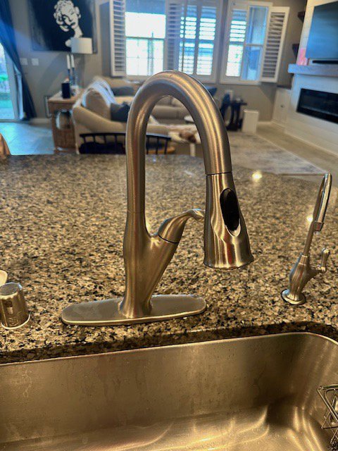 A modern brushed nickel kitchen faucet installed over a granite countertop by Henderson Handyman in Henderson, NV
