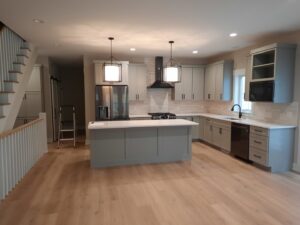 Kitchen finishing work with a ladder and installed cabinets, showcasing handyman services by Woods Builders in Grand Rapids, MI.