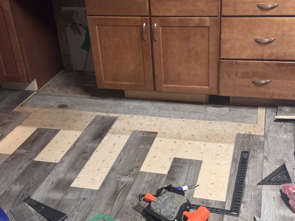 Kitchen flooring installation in progress with tools visible, performed by Hawk Handyman Services in West Fargo, ND