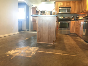 A kitchen with old flooring removed, showing the subfloor before a new installation by MSL Construction in Salem, OR
