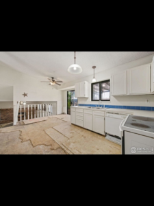 A kitchen with white cabinets and exposed subfloor, showing renovation work by Radiant Homes LLC in Denver, CO.