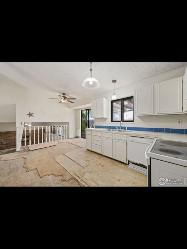 A kitchen with white cabinets and exposed subfloor, showing renovation work by Radiant Homes LLC in Denver, CO.