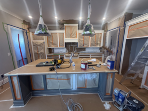 A kitchen fully prepped and taped off for painting by Sherwood Painting Services in Mooresville, NC.