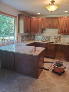 Newly installed granite countertops and tile backsplash in a kitchen by Affordable Granite of KC in Kansas City, MO.