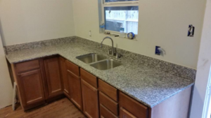 New light speckled granite countertops and a double sink installed in a kitchen by Alfortish Marble & Granite, LLC in Baton Rouge, LA.