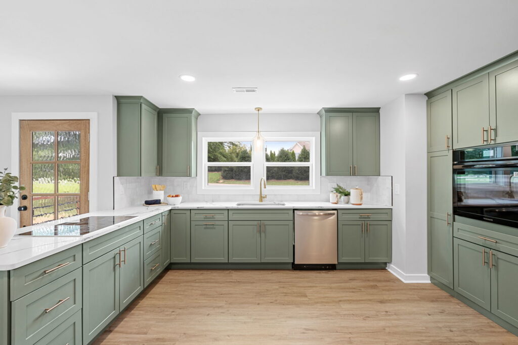 A kitchen featuring green cabinets and white countertops installed by Heroic Builders LLC in Greenville, SC.