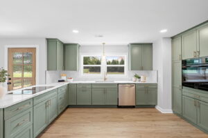 A kitchen featuring green cabinets and white countertops installed by Heroic Builders LLC in Greenville, SC.