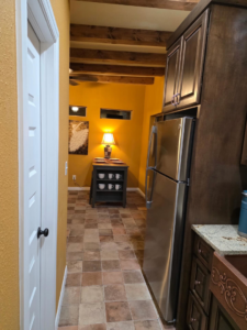 A renovated kitchen and hallway with new flooring and exposed beams by A&R Home Improvements in El Paso, TX