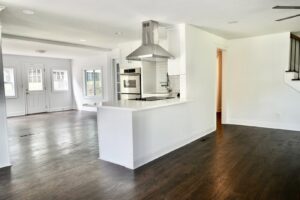 A modern kitchen with newly installed dark hardwood floors by Glenni Floors LLC in Roswell, GA.
