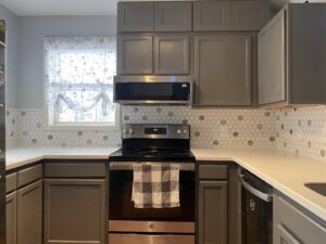A newly installed hexagonal tile backsplash in a kitchen with grey cabinets by Goubar Tile And More in Raleigh, NC.