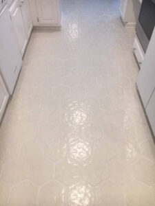 A kitchen floor featuring stylish hexagonal tile installation by True Alchemy - Tile & Grout Restoration in Denver, CO.