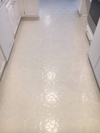 A kitchen floor featuring stylish hexagonal tile installation by True Alchemy - Tile & Grout Restoration in Denver, CO.