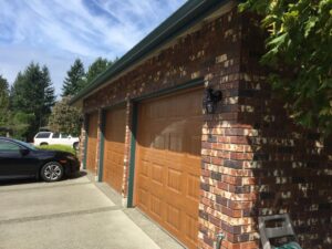A kitchen with dark green walls and white cabinets, showcasing interior painting by Brush N' Roll Painting Co. in Federal Way, WA.