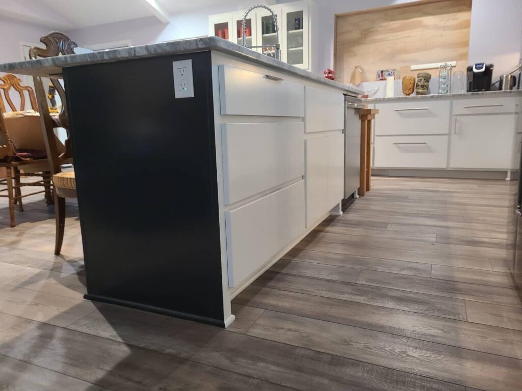 Close-up of a kitchen island with custom cabinetry and an electrical outlet, installed by Holaway Custom Builds in Fayetteville, AR.