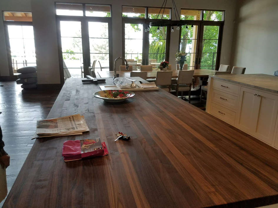 A spacious kitchen island with a dark wood countertop, part of a kitchen remodel by Lilac Remodel Spokane in Spokane Valley, WA.