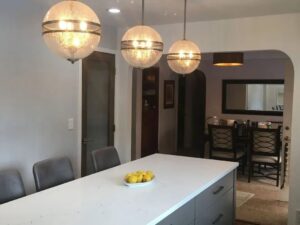A kitchen island with modern pendant lights, leading to a dining area, completed by Myers & Myers Construction in Spokane, WA.