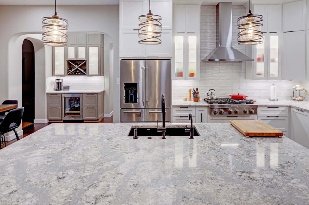 A kitchen island with granite countertops and a sink, showcasing a renovation by Adams Company in Cedar Park, TX