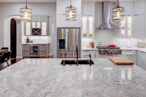 A kitchen island with granite countertops and a sink, showcasing a renovation by Adams Company in Cedar Park, TX