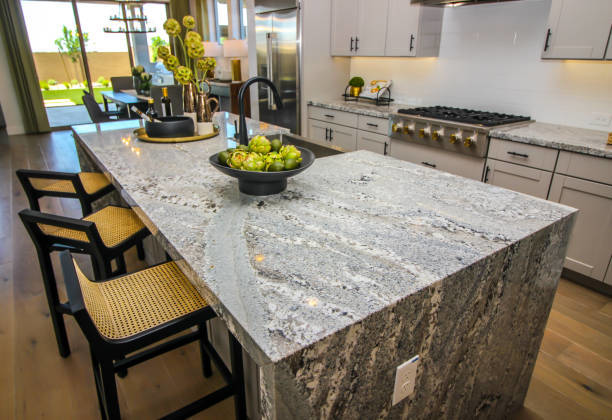 A kitchen island with a beautiful granite countertop and bar stools, completed by North Shore Kitchens in Pittsburgh, PA.
