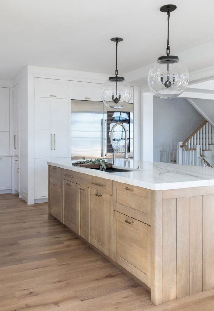 A modern kitchen featuring a large wooden island with a sink and stylish pendant lights, completed by Rapid Restoration and Construction in Mesa, AZ.
