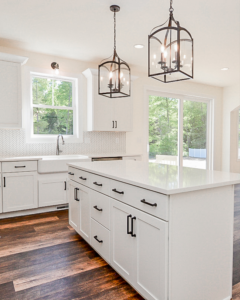A kitchen with a large island and farmhouse sink installed by Pigliavento Associates, LLC, a general contractor in Schenectady, NY.