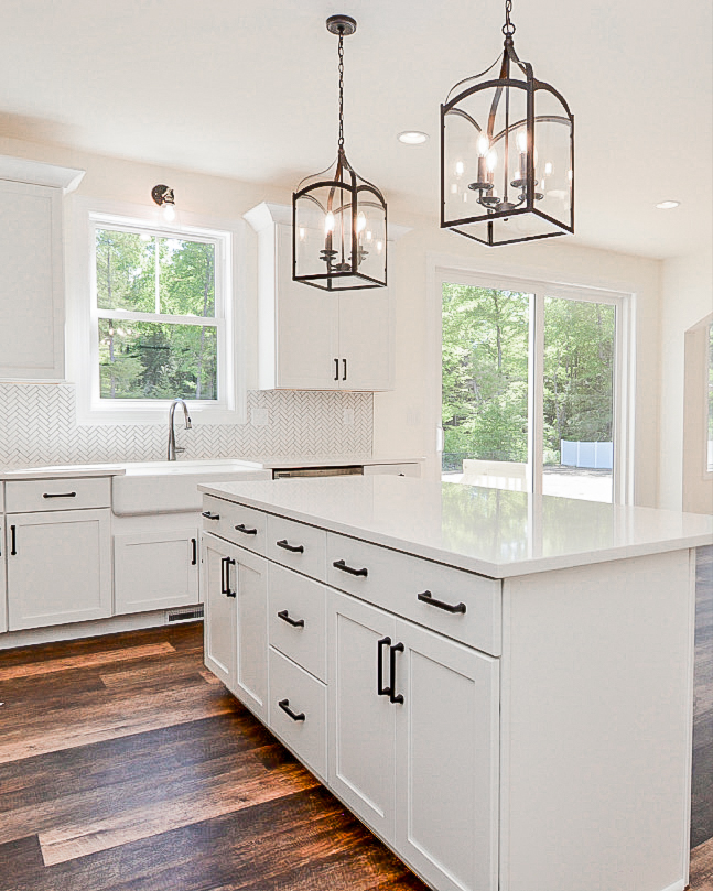 A kitchen with a large island and farmhouse sink installed by Pigliavento Associates, LLC, a general contractor in Schenectady, NY.