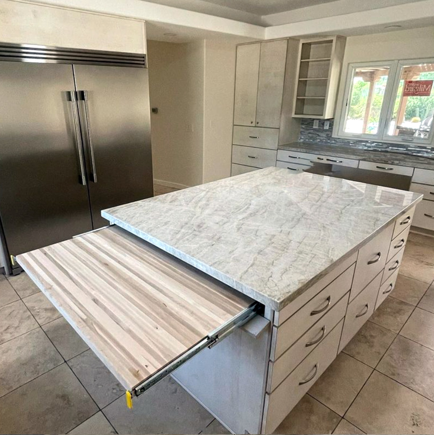 Kitchen island with a marble countertop and a custom pull-out wooden extension by Arizona Cabinet & Countertop Company in Tucson, AZ.