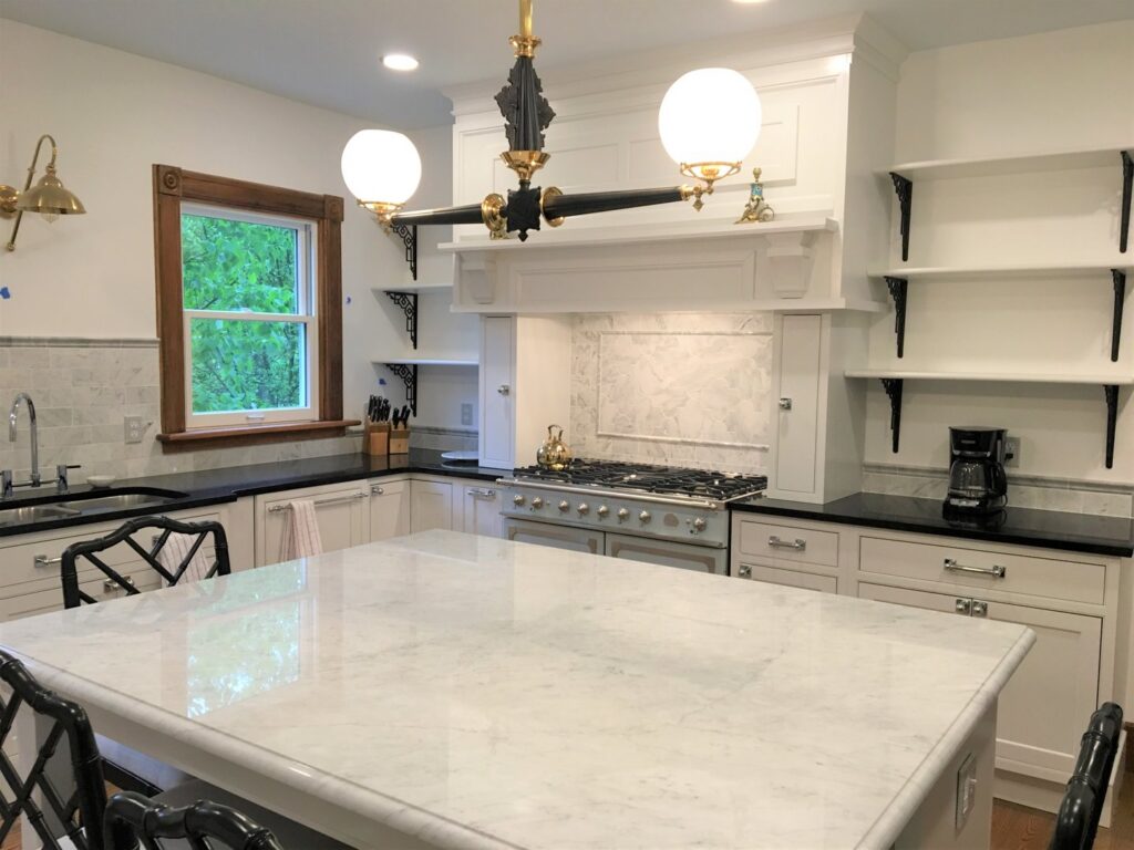 A spacious kitchen featuring a large island with marble countertops and a custom range hood by Adam Ross Cut Stone in Albany, NY.