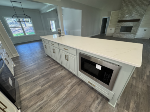 Kitchen island with a built-in microwave and new quartz countertop installed by Adamson Construction Group in Salem, AL.