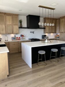 A newly remodeled kitchen featuring a large island, wood cabinets, and modern pendant lighting by A&R Home Improvements in El Paso, TX