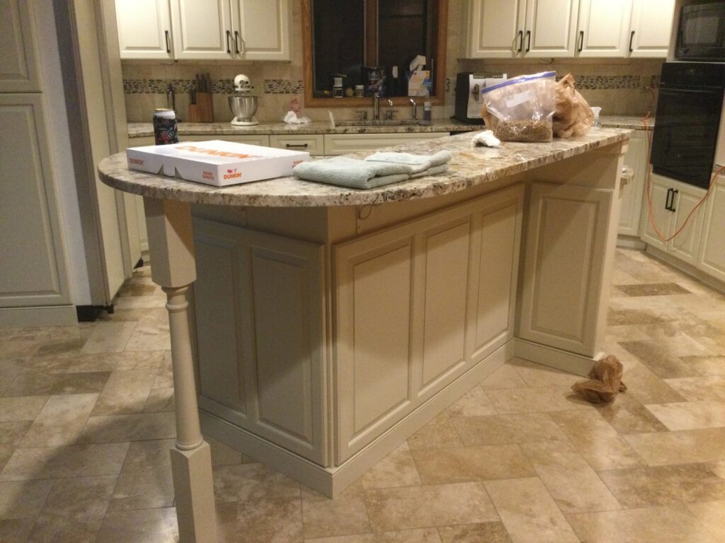 A kitchen island with refaced cabinets and a granite countertop, part of a renovation by Cincinnati Cabinet Refacing in Cincinnati, OH.