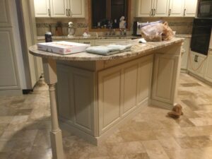 A kitchen island with refaced cabinets and a granite countertop, part of a renovation by Cincinnati Cabinet Refacing in Cincinnati, OH.