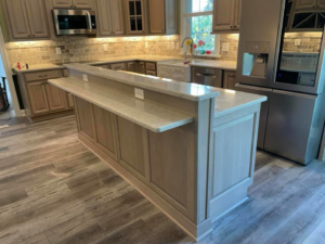 A spacious kitchen featuring a newly installed island with a breakfast bar by Nailed It Custom Remodeling in Chesapeake, VA.
