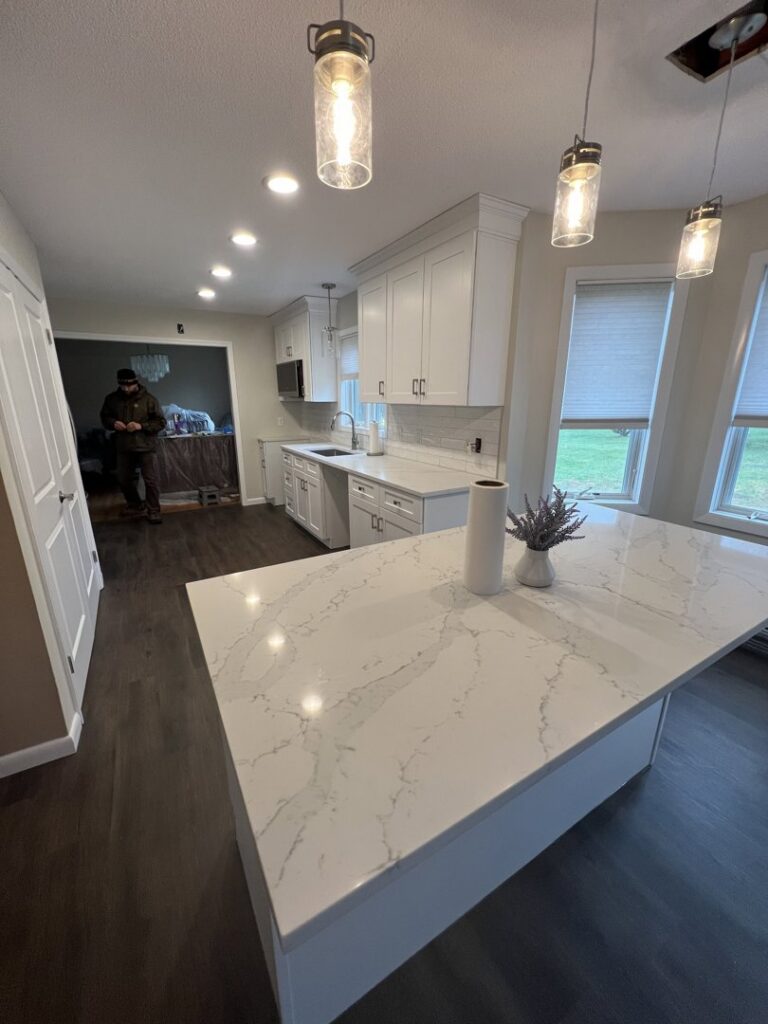 A renovated kitchen featuring a large island and new recessed lighting by Garbatini Contracting in Wallingford, CT.