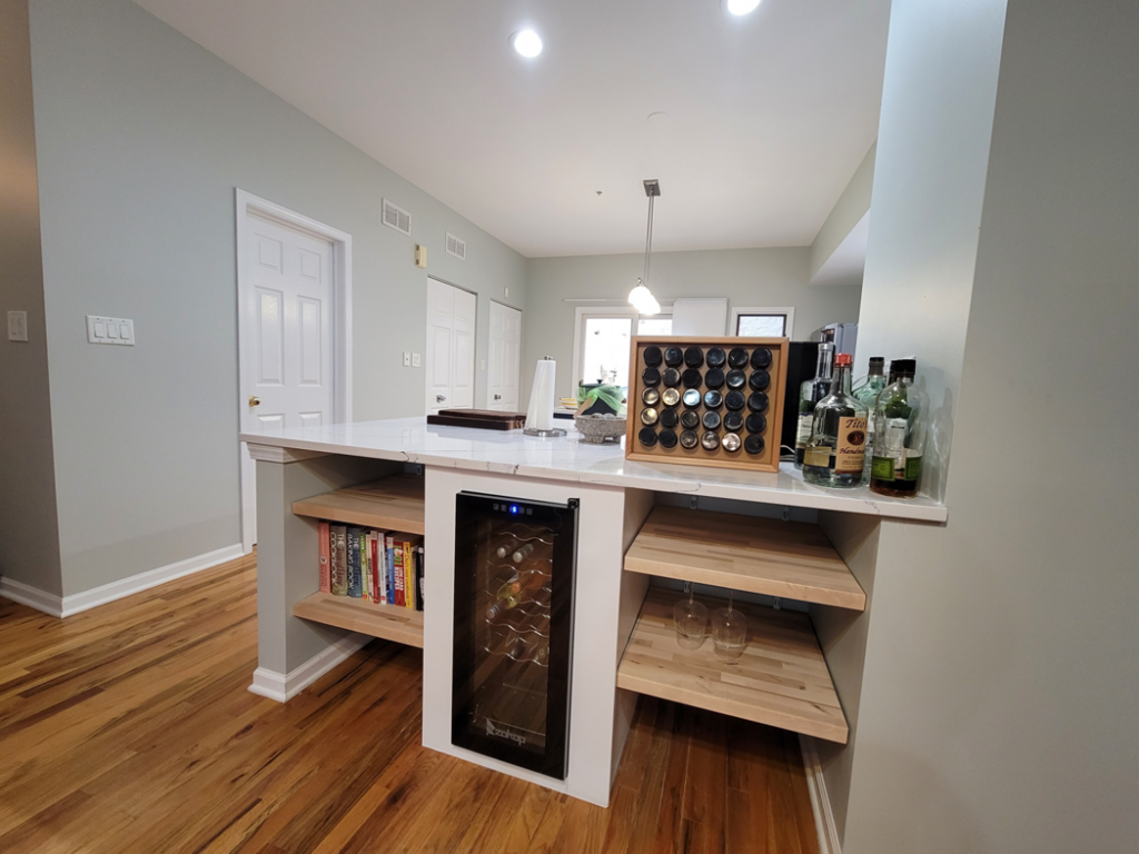 A custom kitchen island with a built-in wine cooler and open shelving, a project by FAV Remodeling Services LLC in Gurnee, IL.