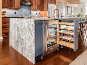 A kitchen island with a built-in wine fridge and pull-out spice rack by Saunders Dynamic Remodeling in Columbus, OH