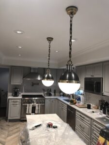 Kitchen light fixture installation in progress with tools and plastic sheeting by AES Electrical Contractor in Richmond, VA.